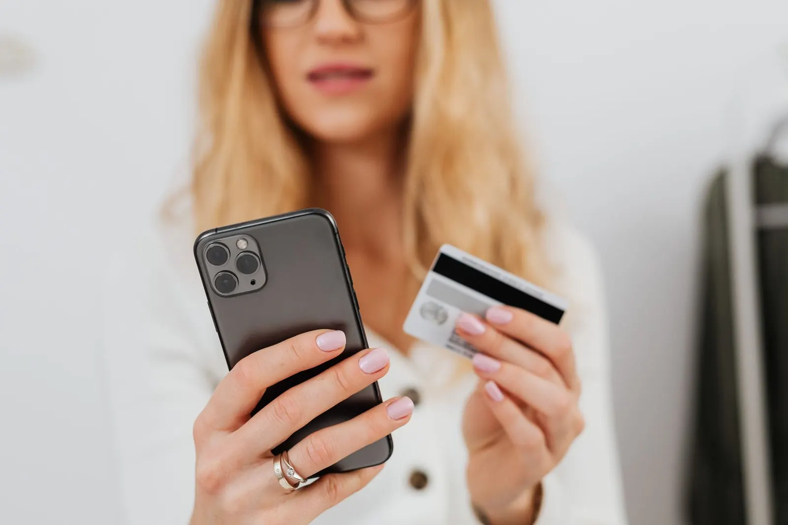 Compradora usando el celular y la tarjeta para completar una compra online